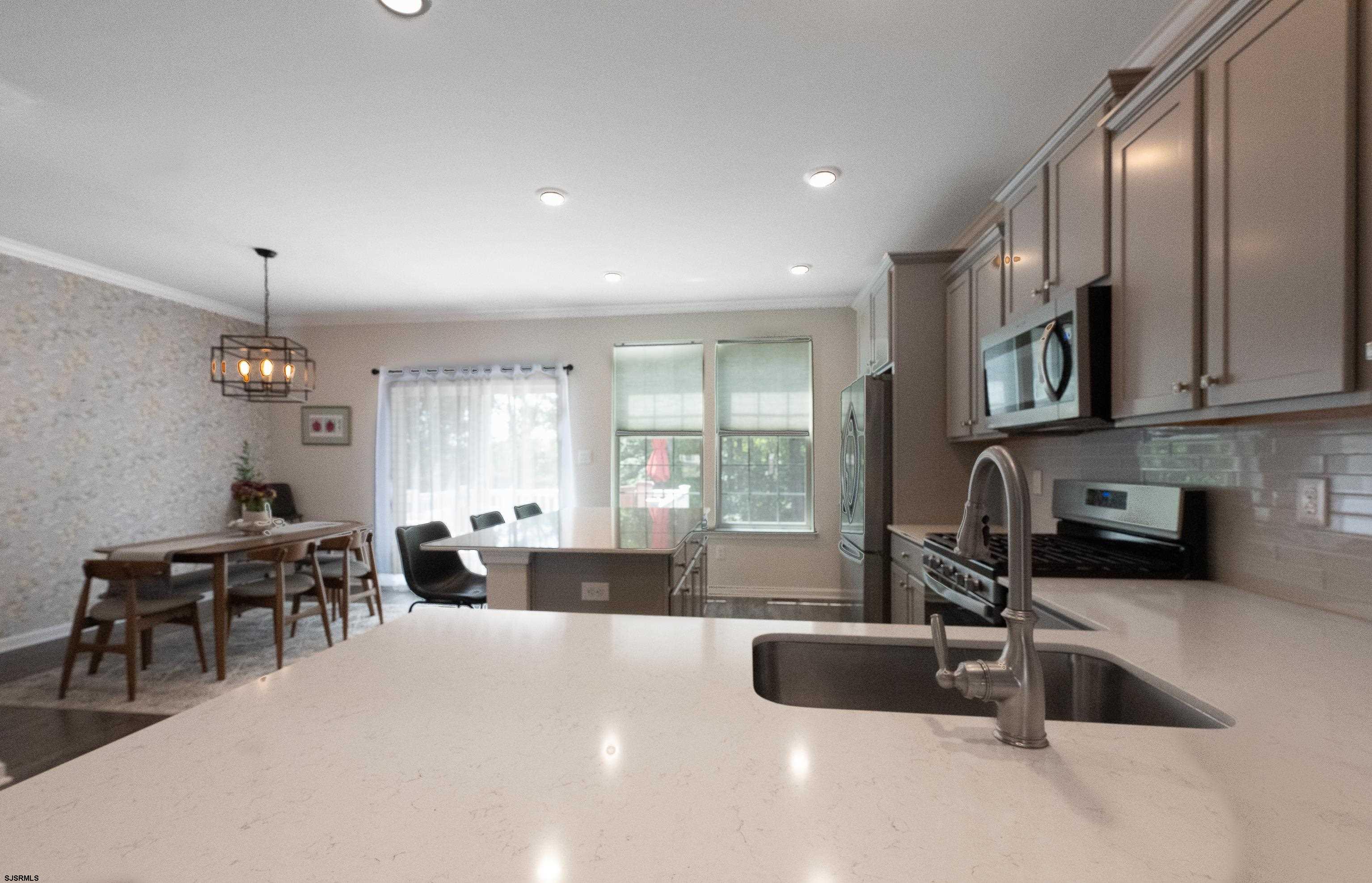 18 Lilac Circle Mount Laurel, NJ 08054 - Photo 26 of 52 a large kitchen with stainless steel appliances a stove a sink a dining table and chair with the outer view