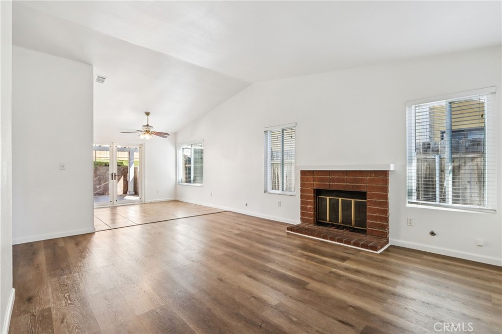 12059 Elk Boulevard Riverside, CA 92505 - Photo 6 of 29 an empty room with wooden floor fireplace and windows