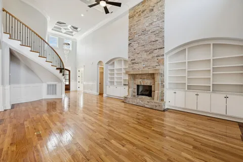 a view of empty room with wooden floor and fireplace