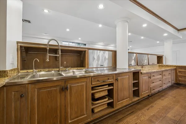 a view of an empty room with kitchen and window