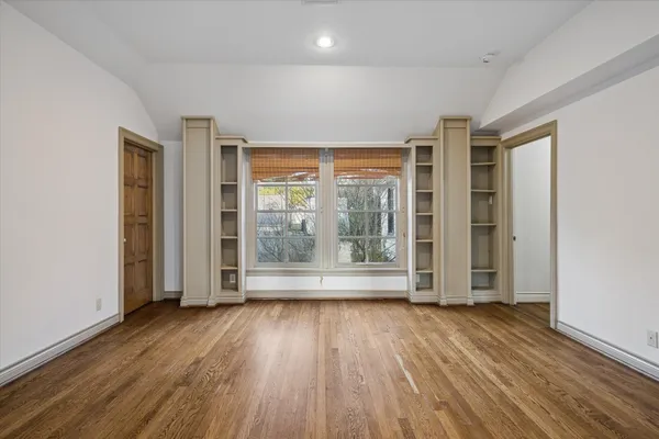 a view of a hallway with wooden floor and glass door