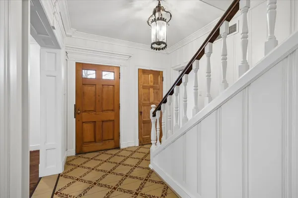 a view of staircase with wooden floor and chandelier