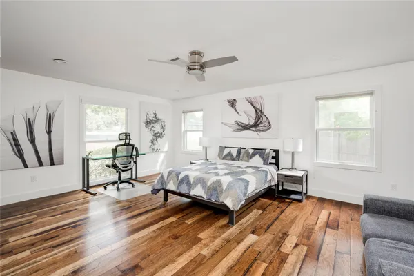 a bedroom with two beds and a dresser next to a window