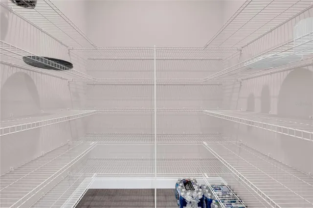 a kitchen with stainless steel appliances kitchen island granite countertop a refrigerator a sink dishwasher and white cabinets with wooden floor