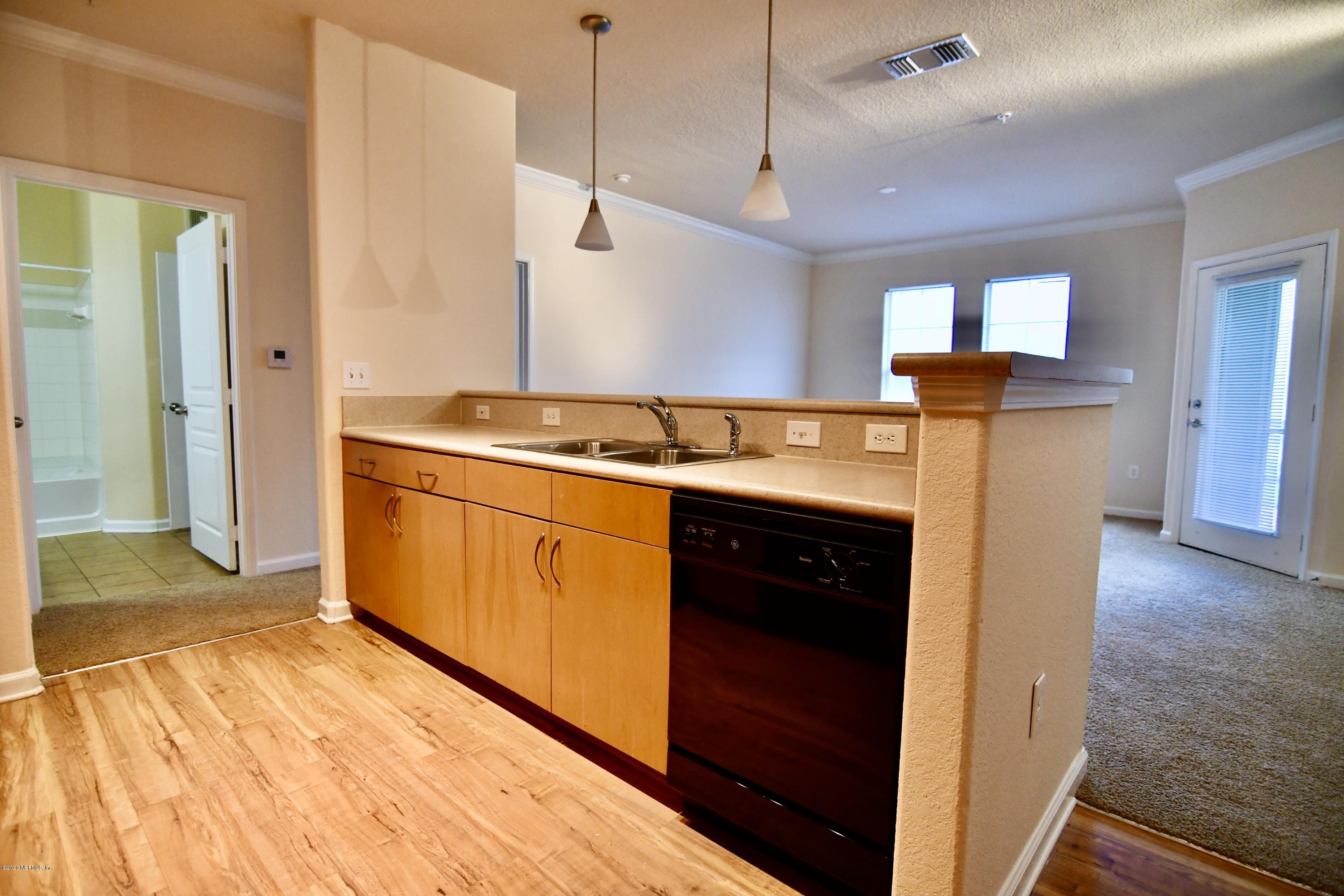 a kitchen with kitchen island a stove a refrigerator and a wooden floor