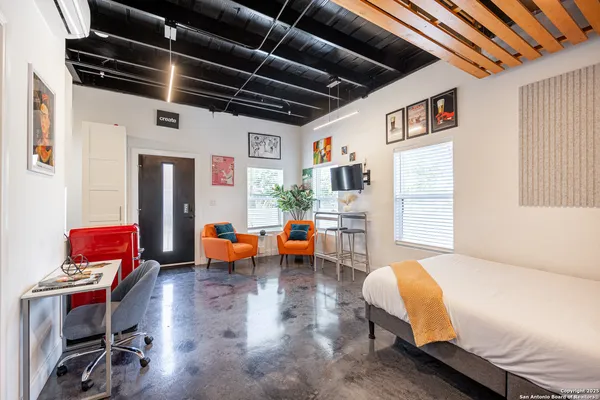 a spacious bedroom with a bed and a flat screen tv