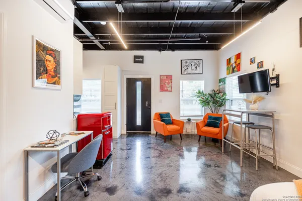 a living room with furniture a flat screen tv and kitchen view