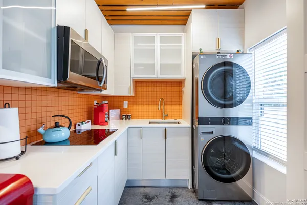 a kitchen with stainless steel appliances a sink a stove and cabinets