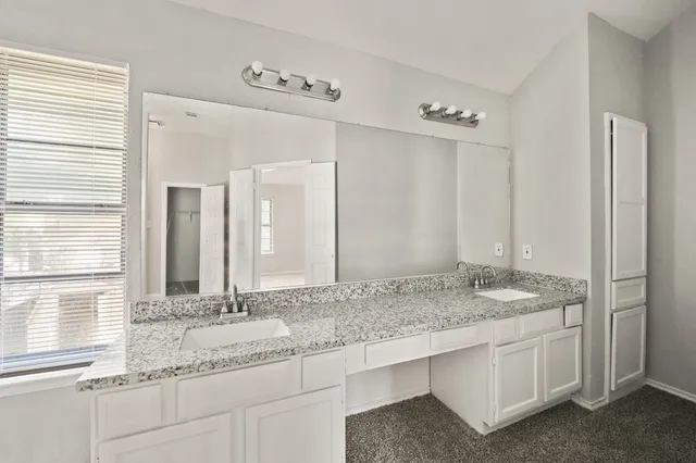 a bathroom with a granite countertop sink and a mirror