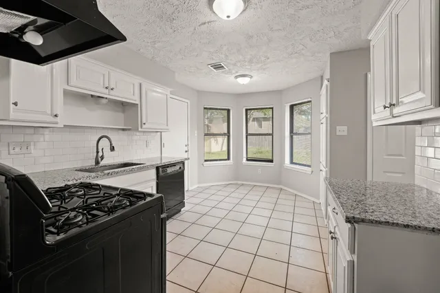 a kitchen with granite countertop a stove and a sink