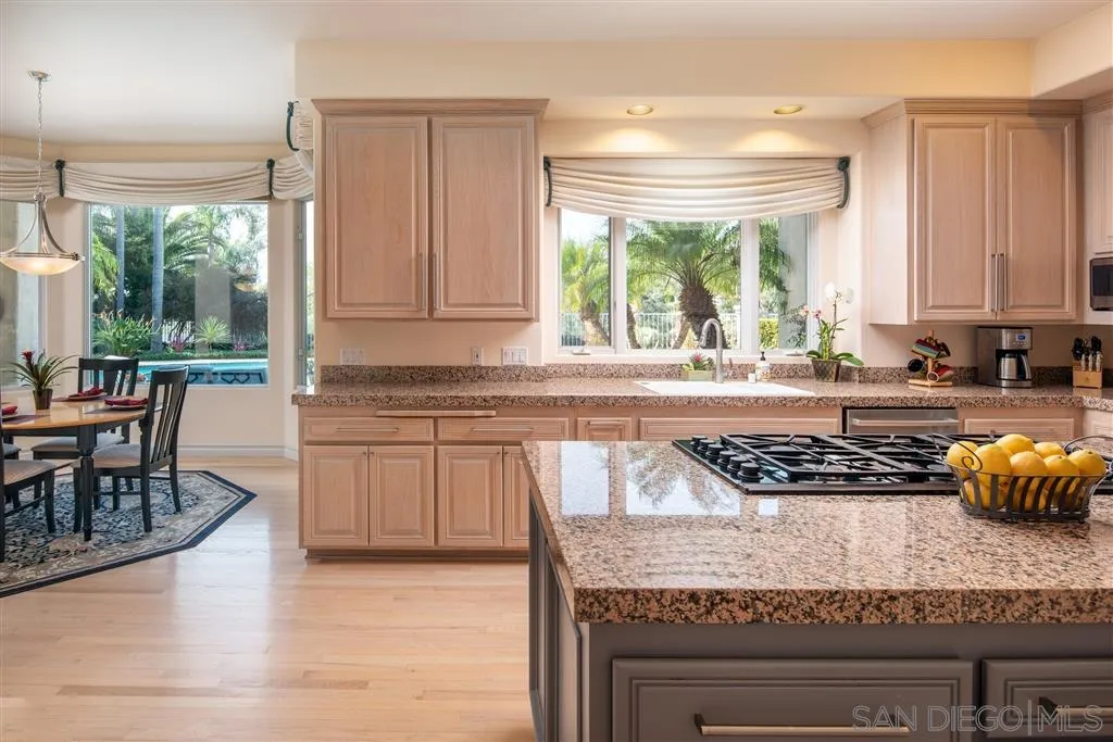 7430 St Andrews Road Rancho Santa Fe, CA 92067 - Photo 13 of 25 a kitchen with granite countertop a stove a sink and a wooden cabinets