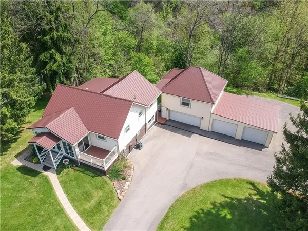 an aerial view of a house with garden space and a lake view