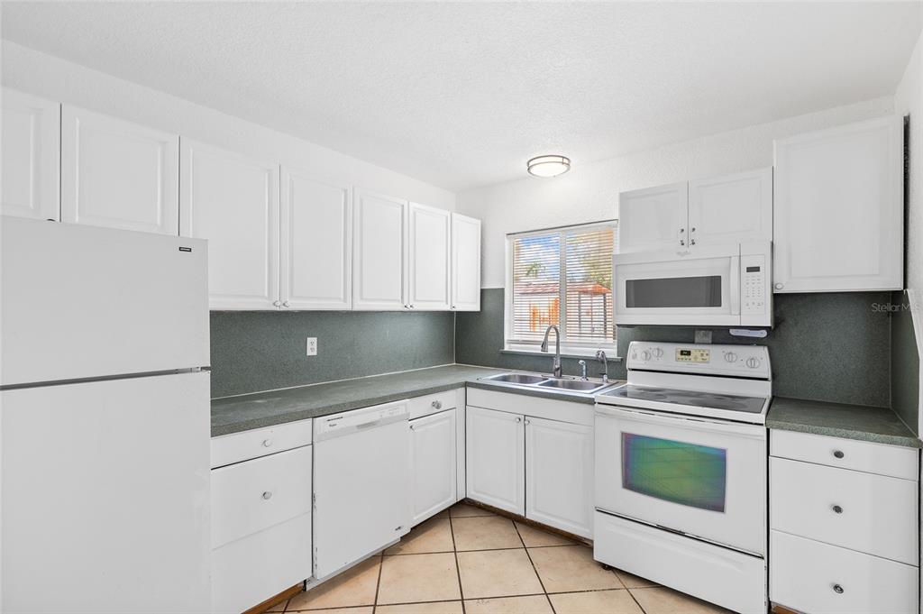 2196 Bell Cheer Drive Clearwater, FL 33764 - Photo 16 of 55 a kitchen with cabinets appliances a sink and a counter top