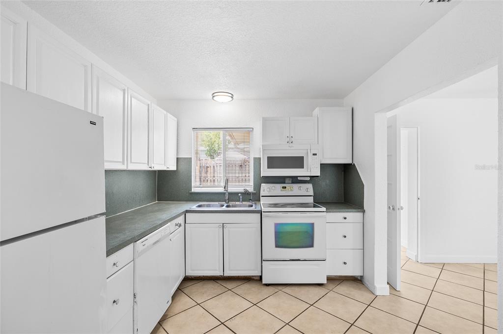 2196 Bell Cheer Drive Clearwater, FL 33764 - Photo 17 of 55 a kitchen with white cabinets stainless steel appliances and a sink
