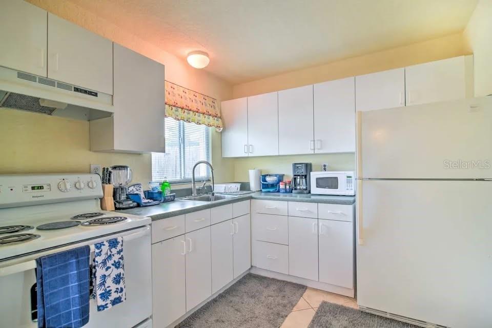 2196 Bell Cheer Drive Clearwater, FL 33764 - Photo 25 of 55 a kitchen with a sink a stove a refrigerator and cabinets
