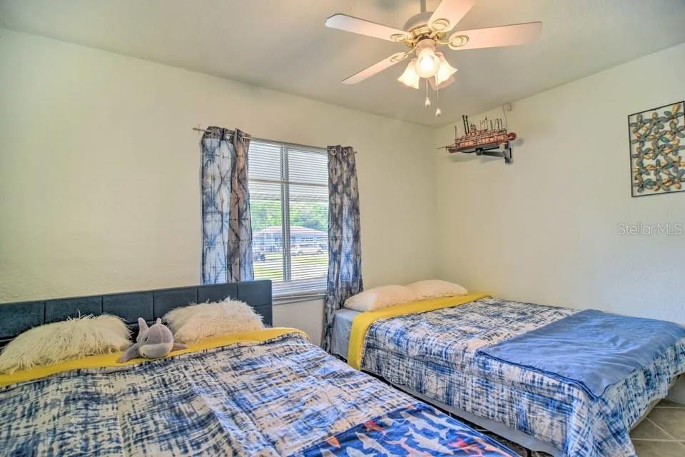 2196 Bell Cheer Drive Clearwater, FL 33764 - Photo 30 of 55 a bedroom with a bed and a chandelier