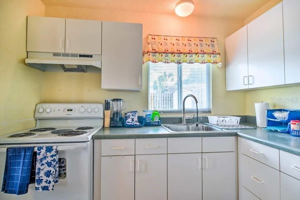 2196 Bell Cheer Drive Clearwater, FL 33764 - Photo 33 of 55 a kitchen with stainless steel appliances granite countertop a stove a sink and a white cabinets