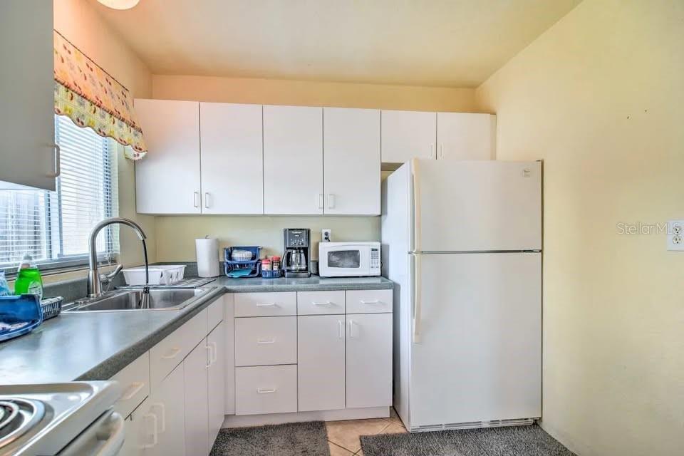 2196 Bell Cheer Drive Clearwater, FL 33764 - Photo 38 of 55 a kitchen with a refrigerator a sink and cabinets