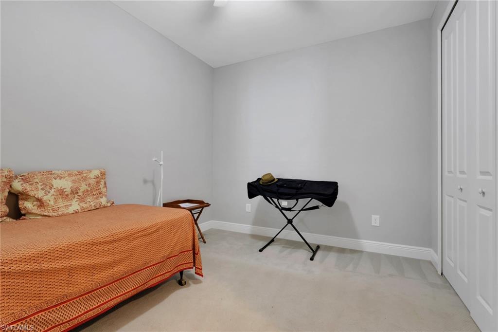 2231 Marquesa Circle Naples, FL 34112 - Photo 20 of 38 a bedroom with a bed and chair