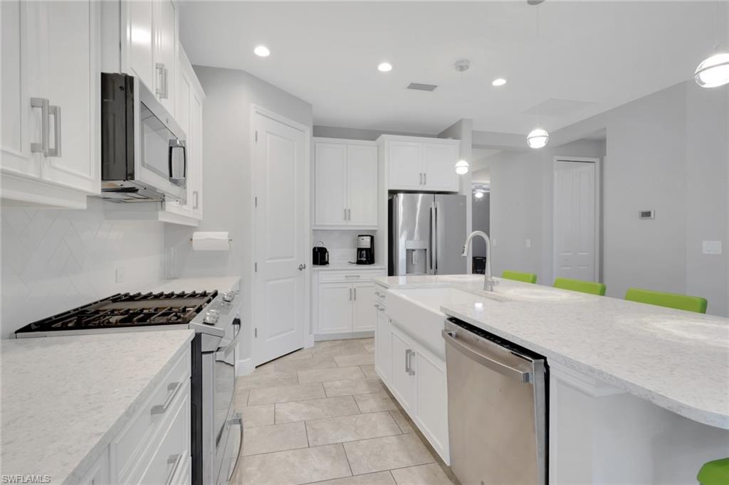 2231 Marquesa Circle Naples, FL 34112 - Photo 5 of 38 a kitchen with a sink a stove a refrigerator and cabinets