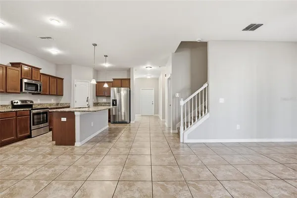 a large kitchen with a large counter top stainless steel appliances and cabinets