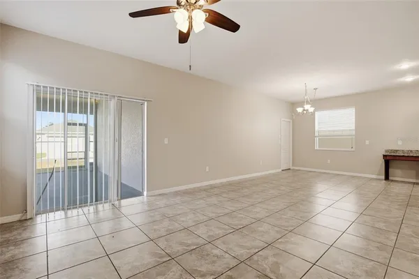 an empty room with fan and windows