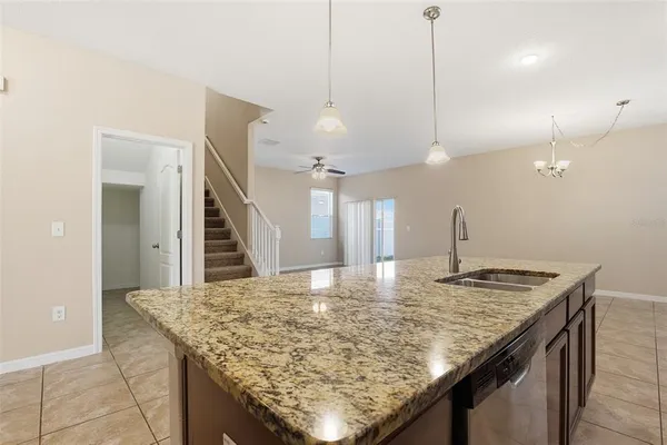 a kitchen with granite countertop kitchen island a sink stove and wooden floor