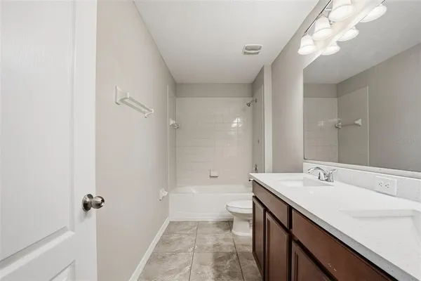 a bathroom with a sink a toilet a large mirror and shower