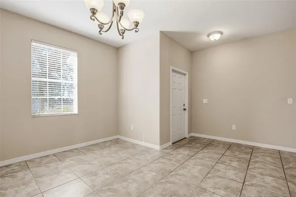 a view of a livingroom with a chandelier fan and windows