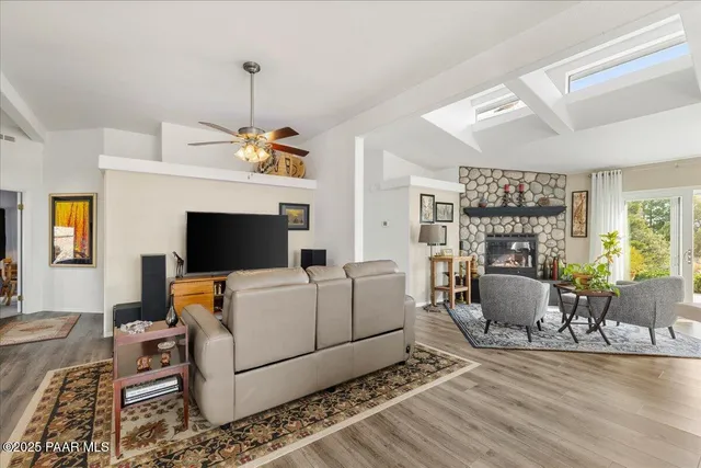 a living room with furniture a flat screen tv and a fireplace