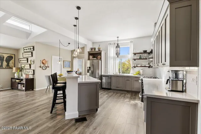 a kitchen with stainless steel appliances granite countertop wooden floors sink and cabinets