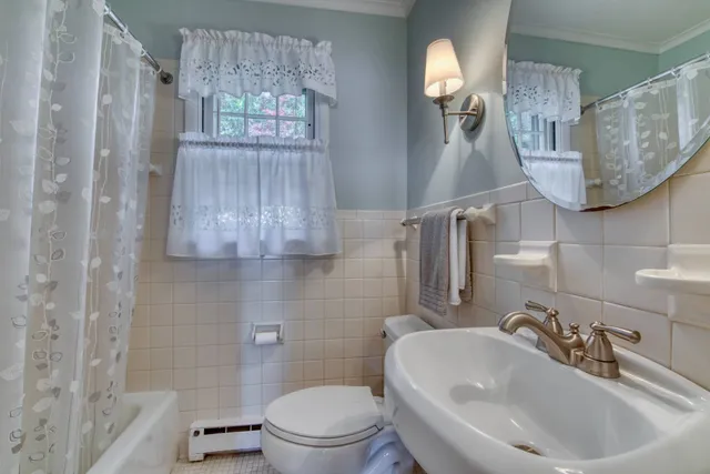 a bathroom with a sink a toilet and mirror