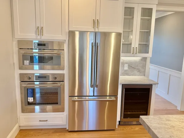 an empty room with wooden floor fireplace and windows