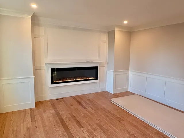 a view of empty room with wooden floor and fireplace