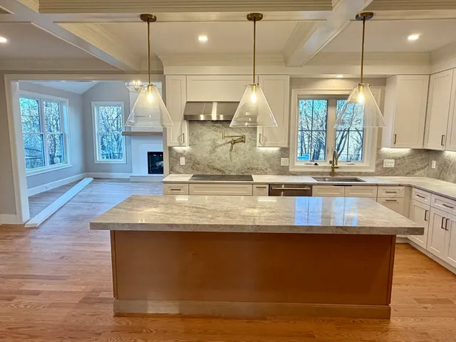 a view of a kitchen counter top a stove and wooden floor