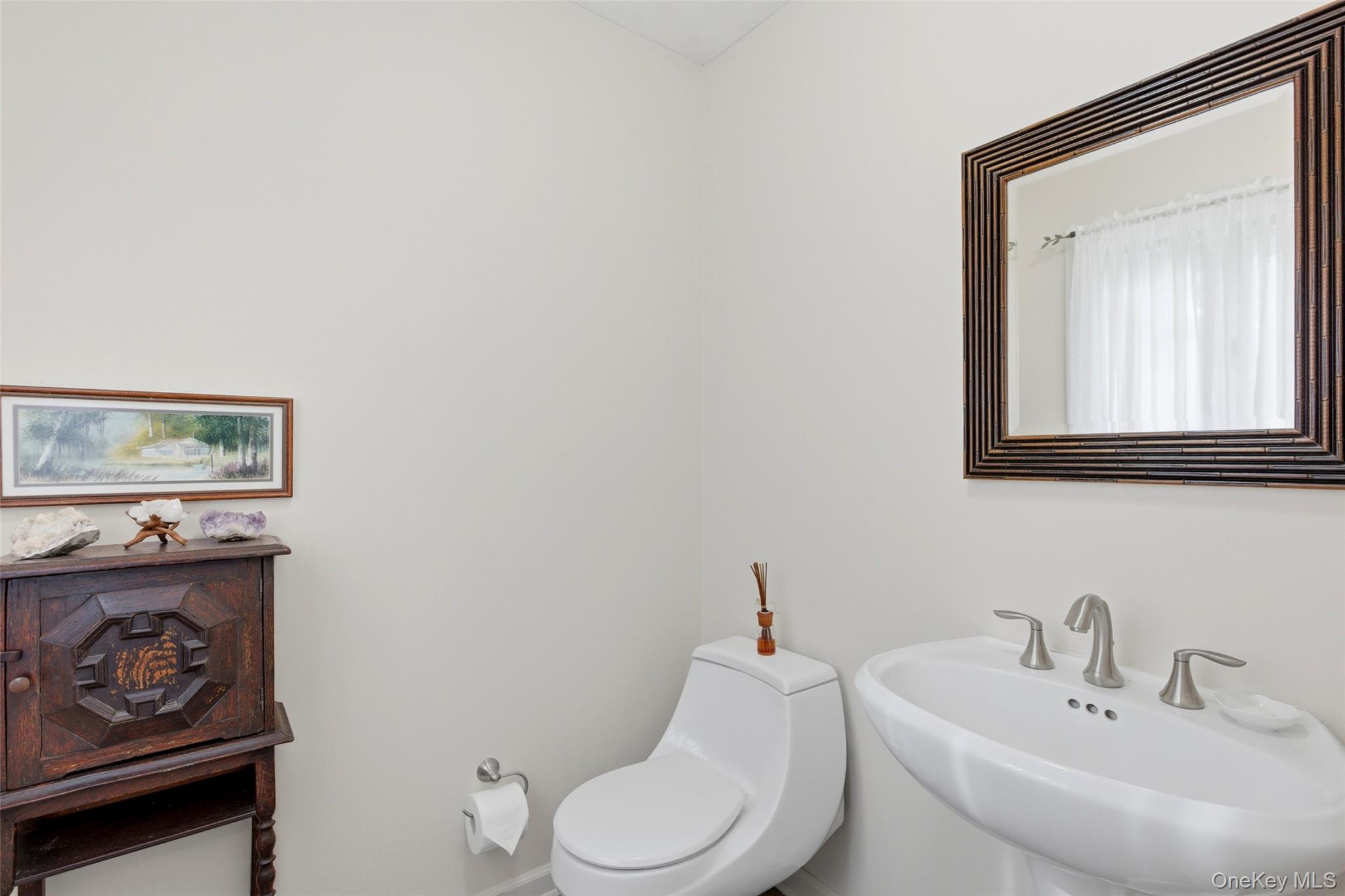 7 Gun Path Setauket, NY 11733 - Photo 17 of 34 a bathroom with a toilet a sink and mirror