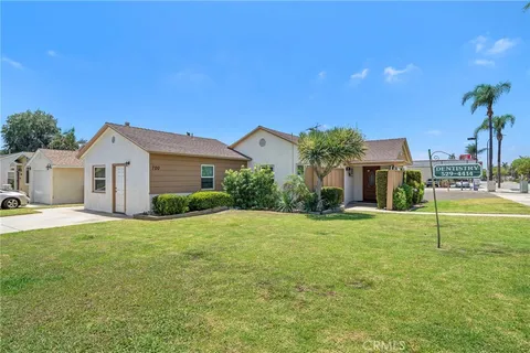 a view of a house with a yard and a tree