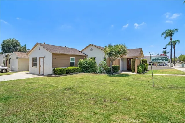 a view of a house with a yard and a tree