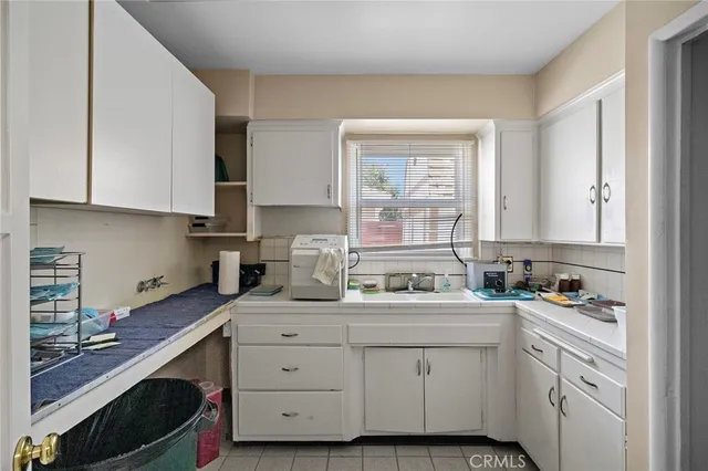 a kitchen with cabinets appliances a sink and a window