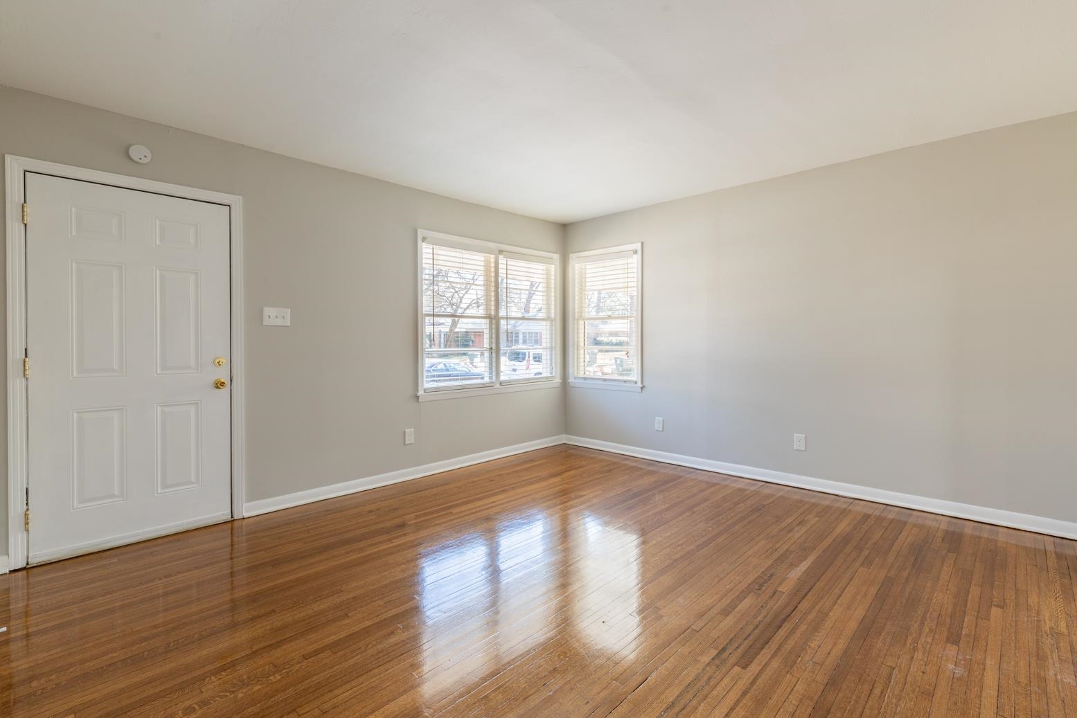 1511 Raymore Road Memphis, TN 38117 - Photo 5 of 21 an empty room with wooden floor and windows