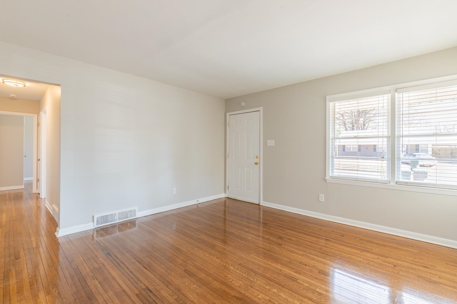 1511 Raymore Road Memphis, TN 38117 - Photo 6 of 21 an empty room with wooden floor and windows