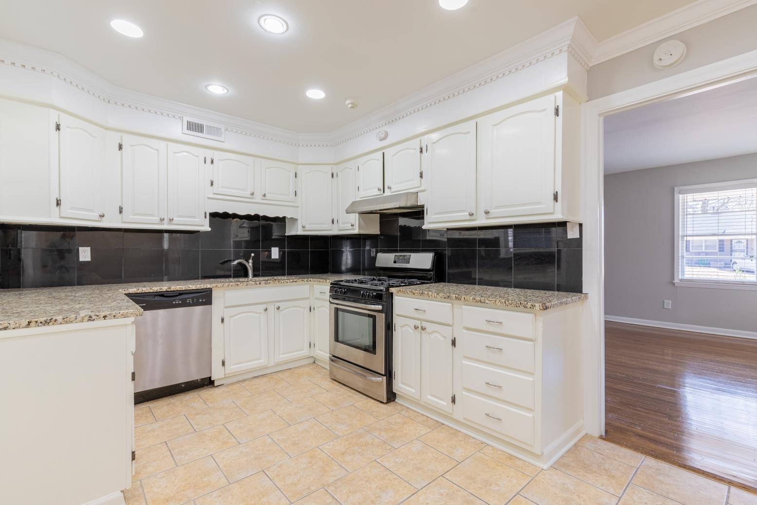 1511 Raymore Road Memphis, TN 38117 - Photo 9 of 21 a kitchen with stainless steel appliances granite countertop white cabinets sink and a stove