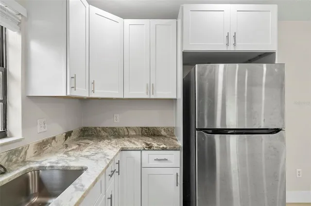 a kitchen with a refrigerator and cabinets