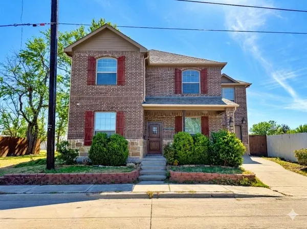 a front view of a house with garage and plants