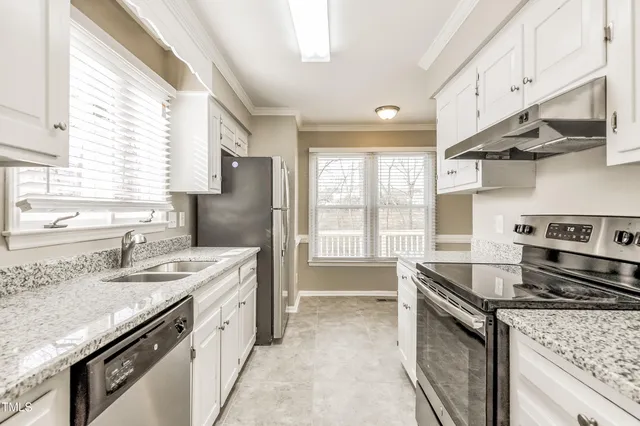 a kitchen with stainless steel appliances granite countertop a sink stove and refrigerator