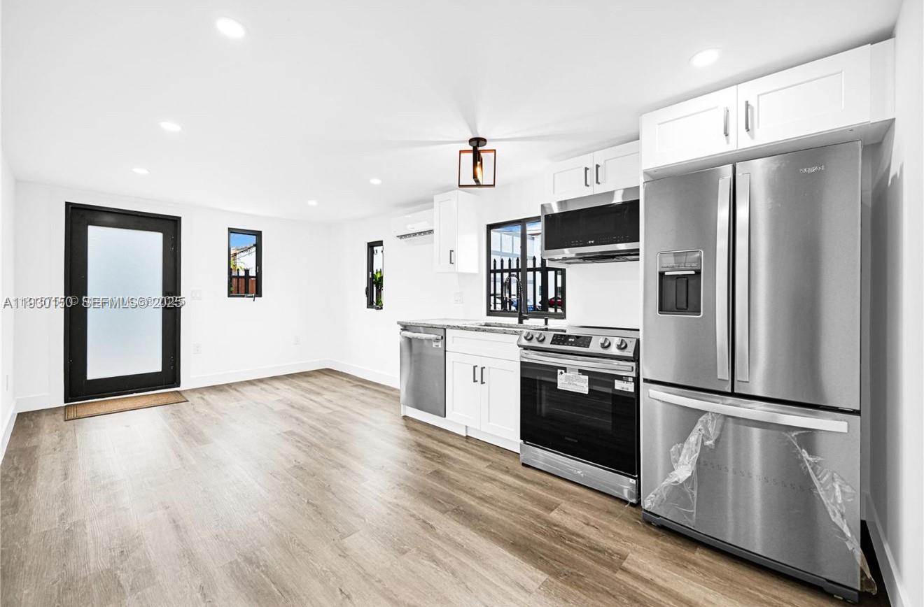 a kitchen with stainless steel appliances wooden floor sink and wooden floors