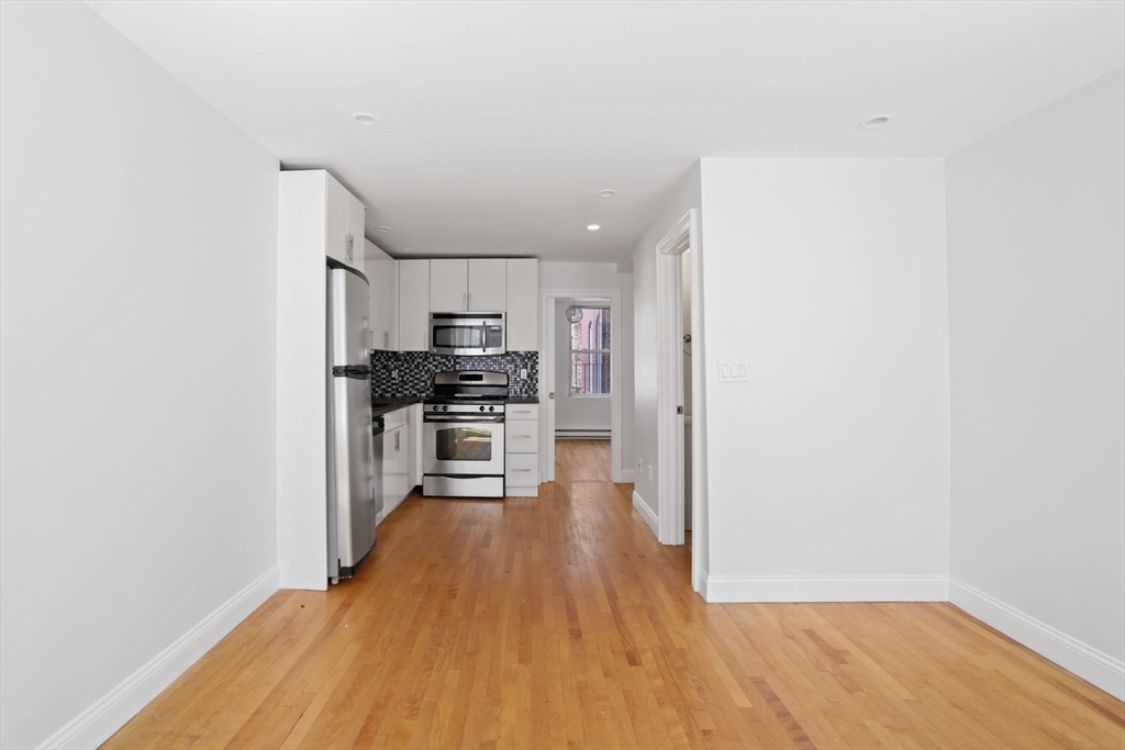 1 Unity Street, Unit 2F Boston, MA 02113 - Photo 3 of 16 a kitchen with stainless steel appliances a refrigerator and a stove top oven