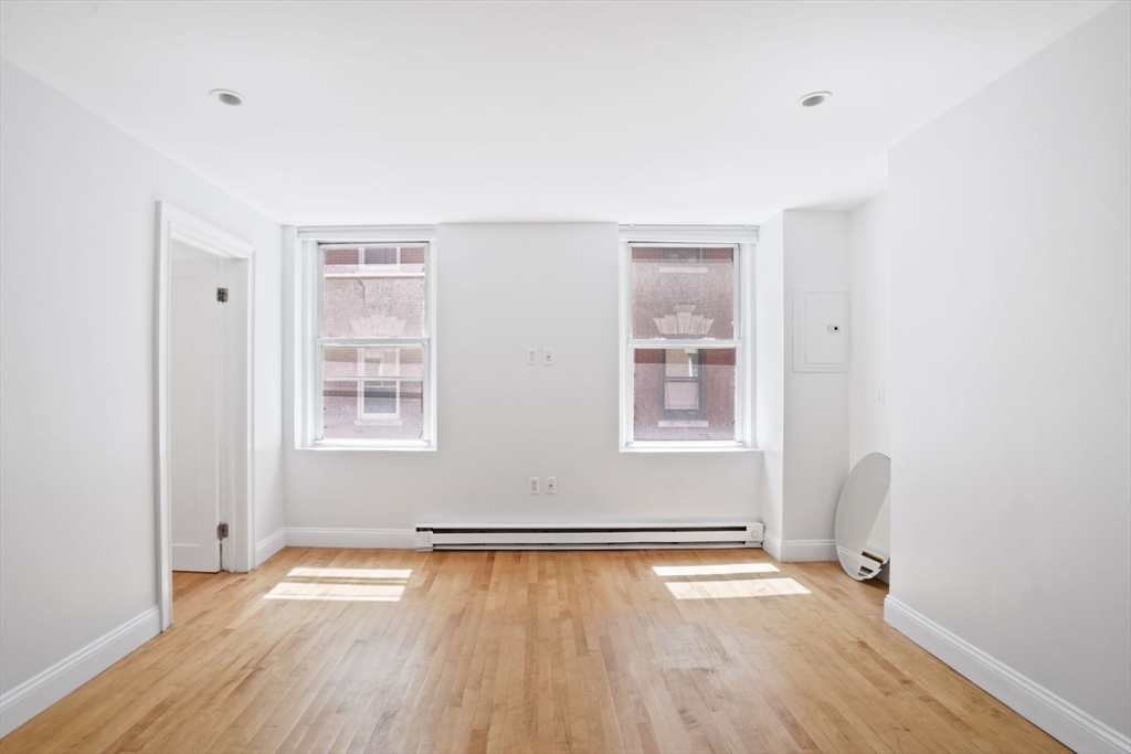 1 Unity Street, Unit 2F Boston, MA 02113 - Photo 5 of 16 an empty room with wooden floor and windows