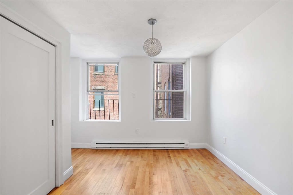 1 Unity Street, Unit 2F Boston, MA 02113 - Photo 8 of 16 an empty room with wooden floor and windows