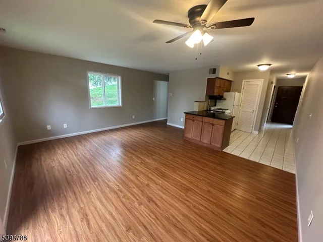 a view of a kitchen with wooden floor a sink and a window